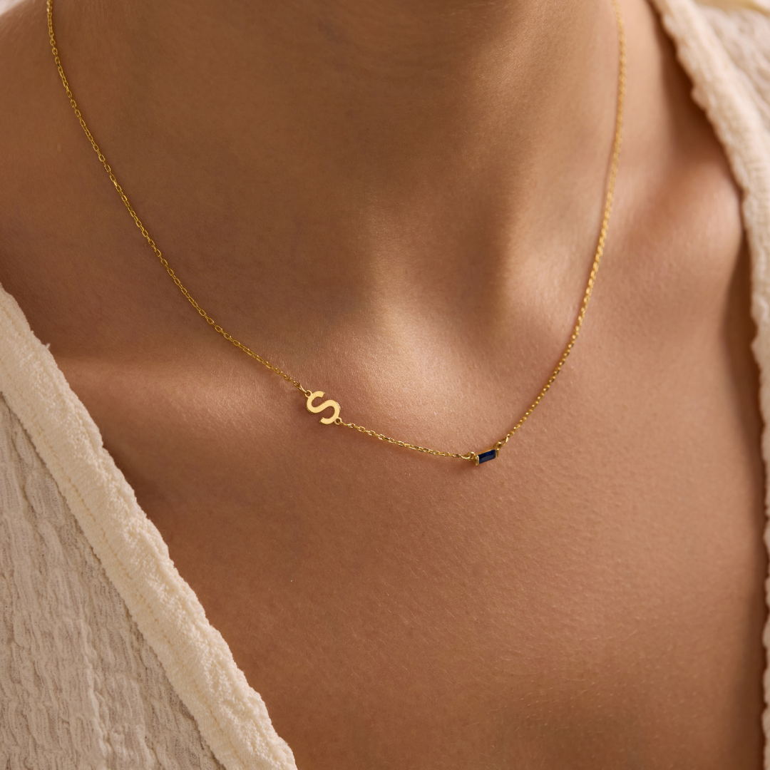 Sideways Initial Birthstone Necklace showing an S initial and a dark blue rectangular stone
