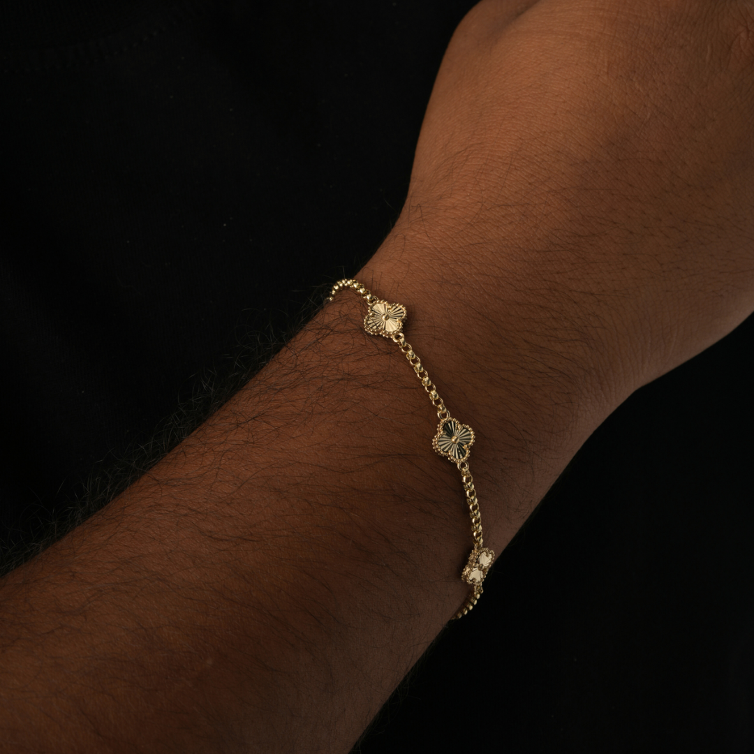 Gold Clover Pendant Bracelet agains black background on mens wrist