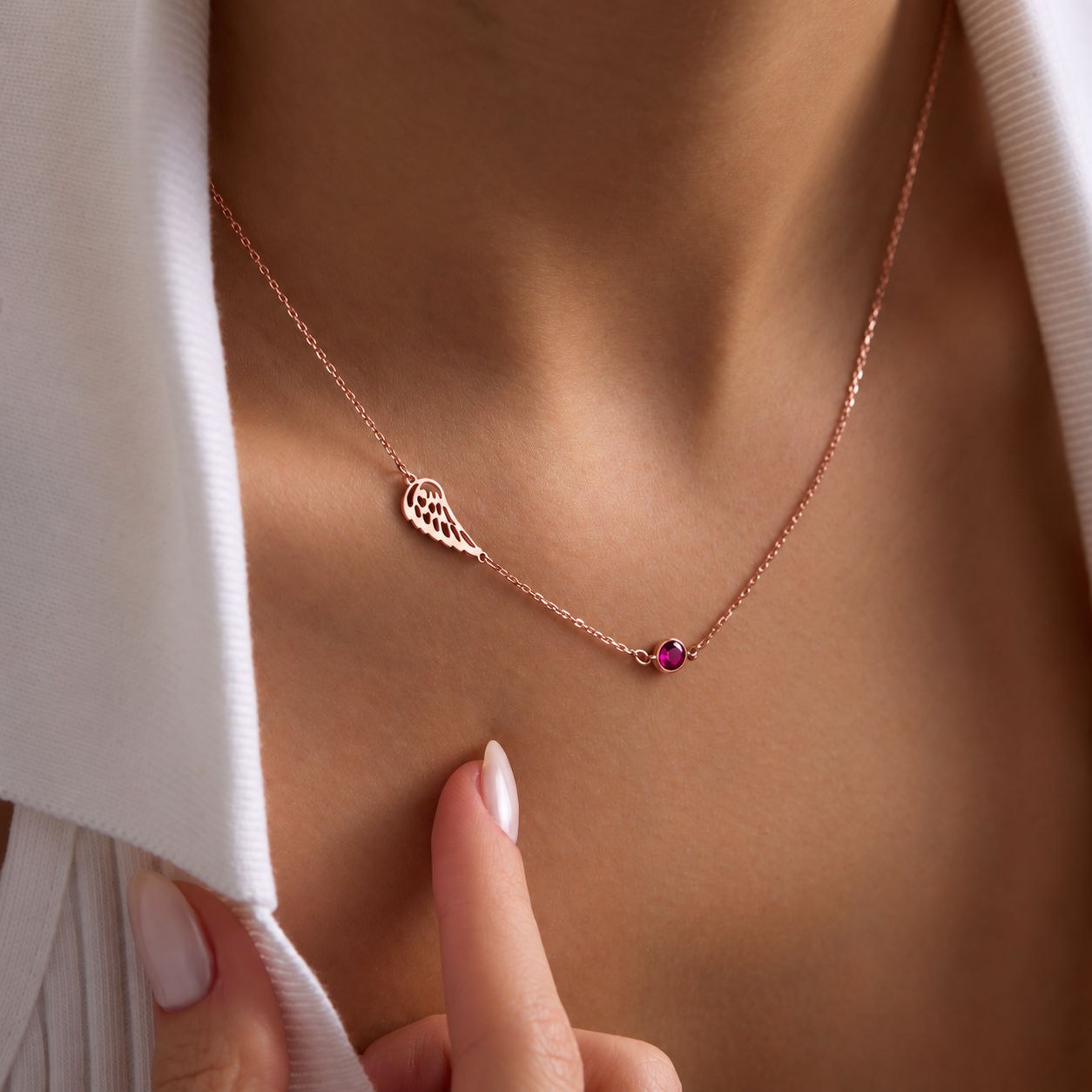 Angel wing memorial necklace in 14K rose gold filled with a pink birthstone, worn on the neck