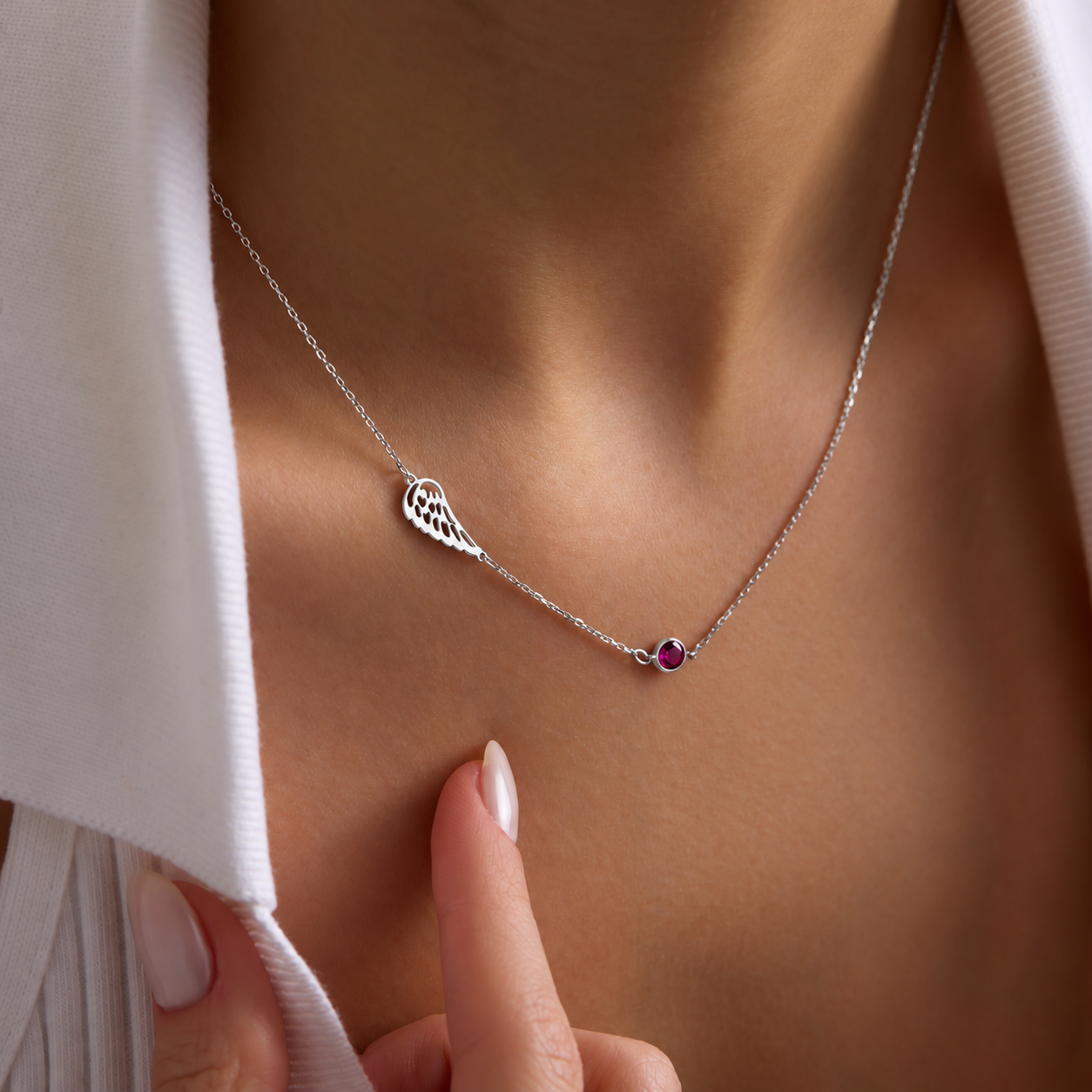 Angel wing memorial necklace in 925 sterling silver with a pink birthstone, worn on the neck