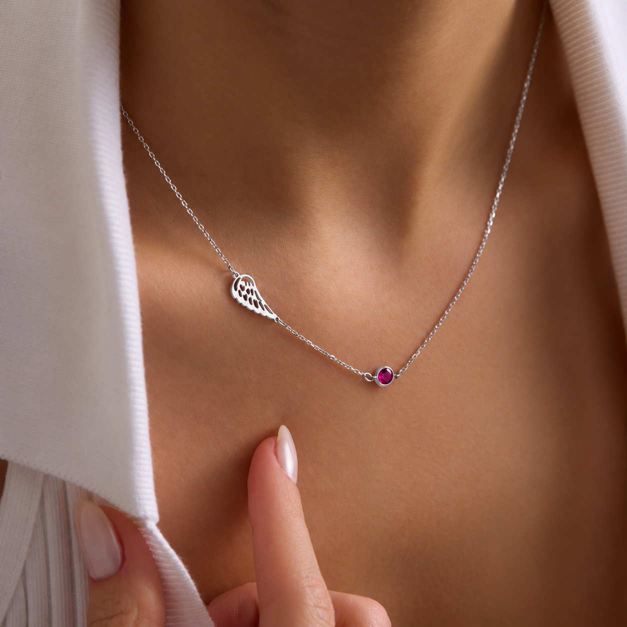 Angel wing memorial necklace in 14K solid white gold with a pink birthstone, worn on the neck