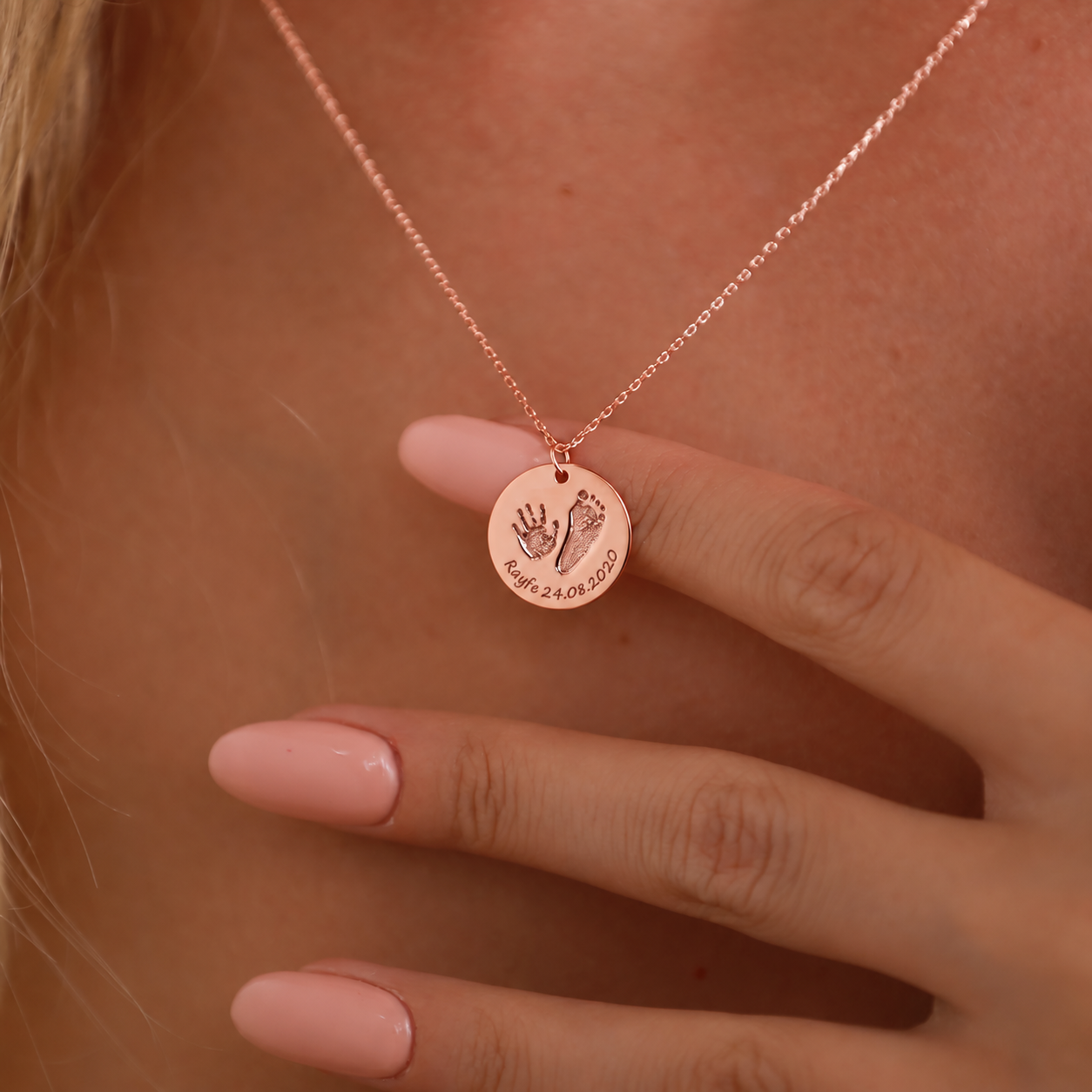 14K rose gold filled baby footprint necklace with an engraved handprint, footprint, name and date, worn close-up