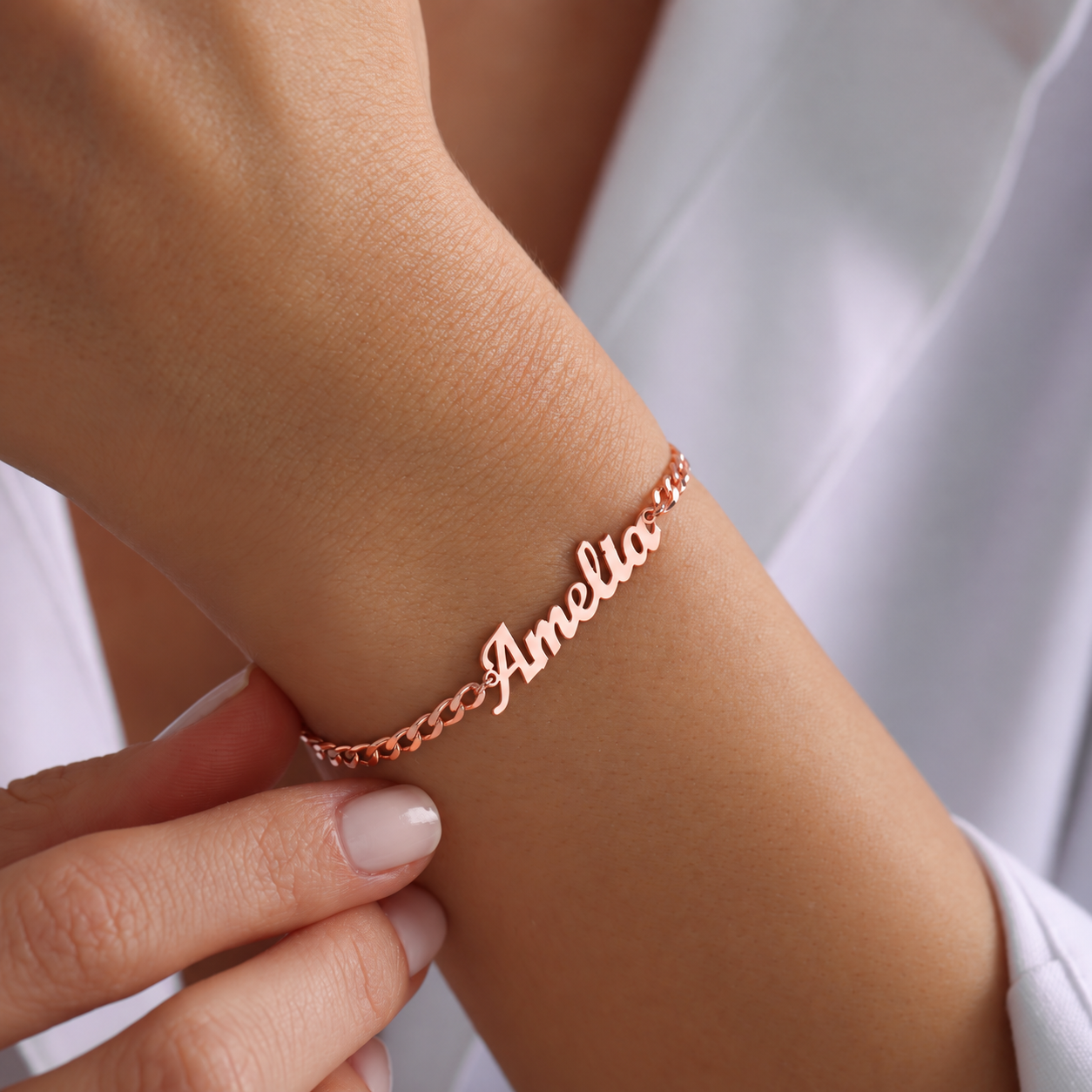 Amelia custom name bracelet in 14K rose gold filled with a curb chain, worn on the wrist