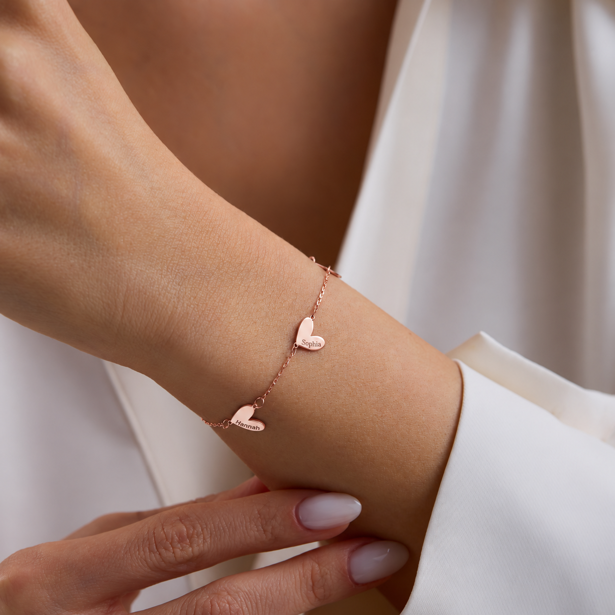 Engraved family heart bracelet in 14K rose gold filled, with Sophia and Hannah charms worn on the wrist