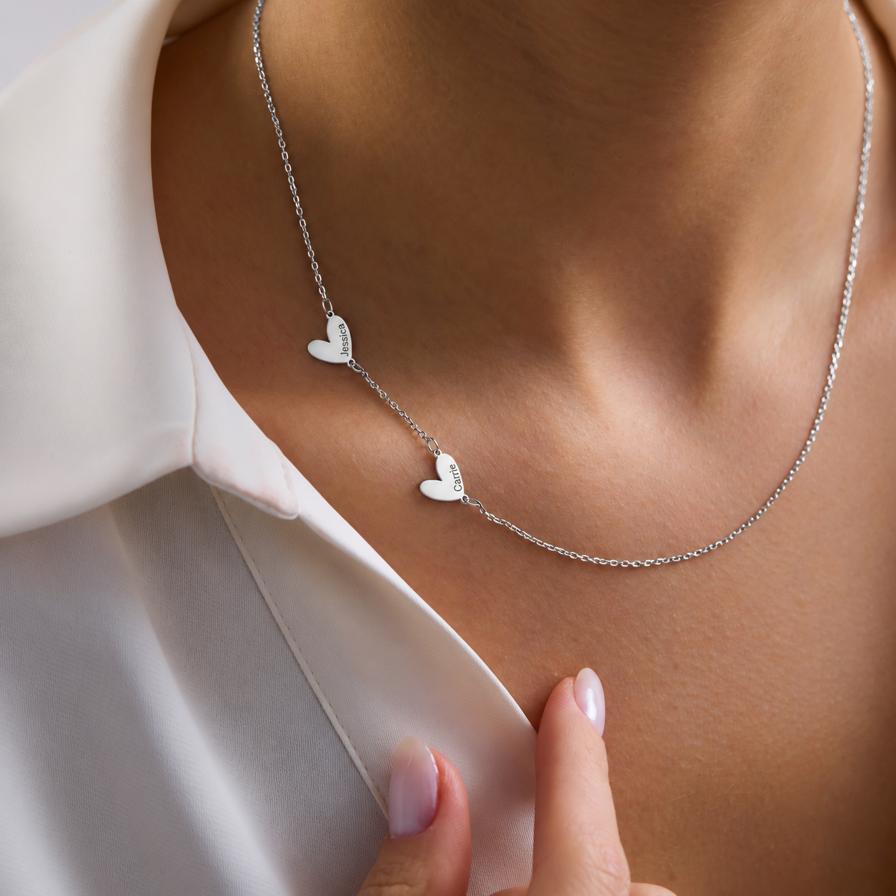Engraved family heart necklace in sterling silver, with Jessica and Carrie charms worn with a white shirt