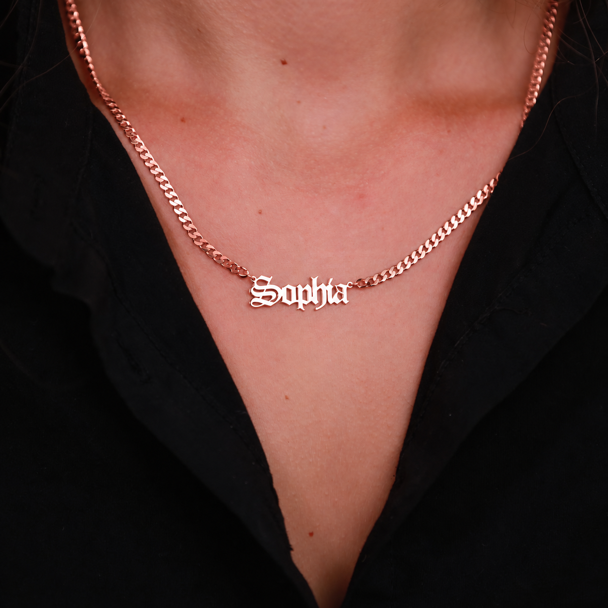 Sophia Old English nameplate necklace in 14K rose gold filled with a curb chain, worn on the neck