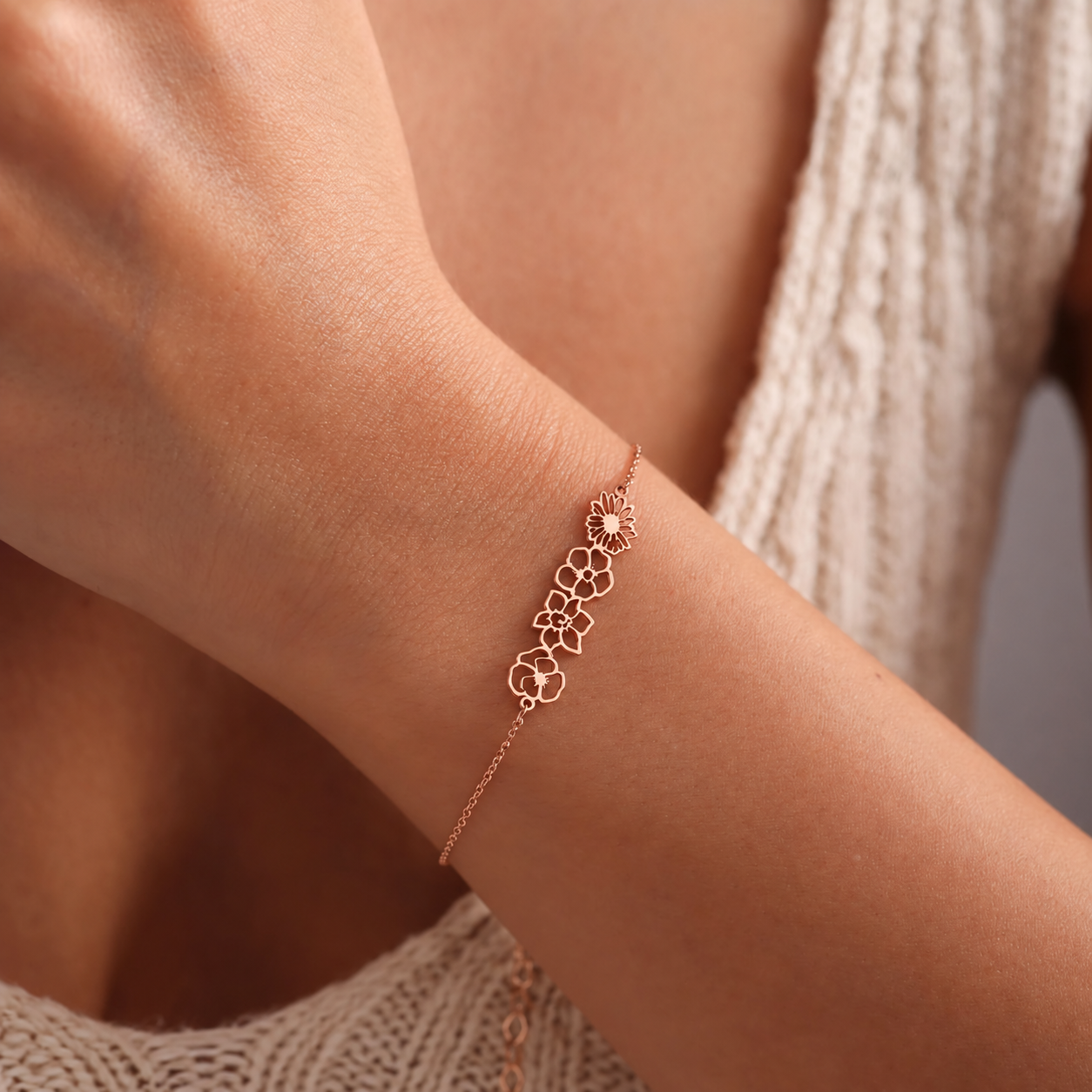 14K rose gold filled personalized birth flower bracelet with four linked openwork flower charms, worn on a wrist